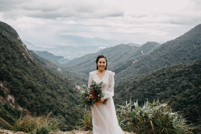 Woman standing on mountain against sky