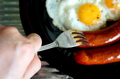 Close-up of cropped hand holding spoon