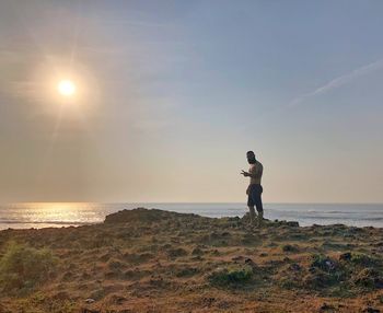 Man standing at beach against sky