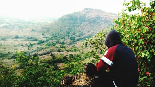 Rear view of woman on mountain against sky