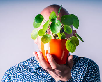 Midsection of man holding fruit against white background