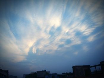 Low angle view of buildings against cloudy sky