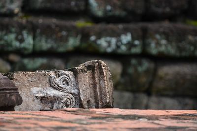 Close-up of statue against stone wall