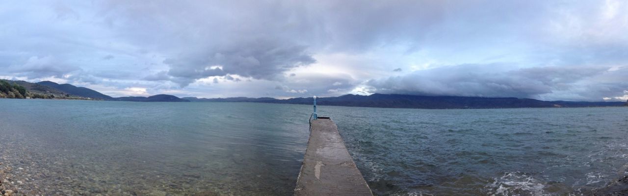 sky, water, cloud - sky, tranquil scene, tranquility, scenics, cloudy, mountain, beauty in nature, nature, cloud, lake, sea, pier, weather, mountain range, idyllic, non-urban scene, the way forward, day