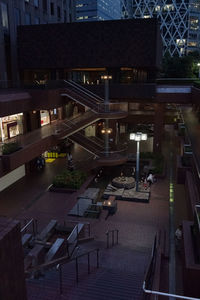 High angle view of illuminated street amidst buildings at night