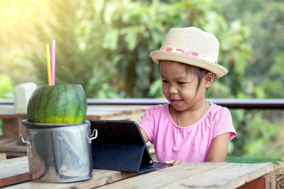 Portrait of girl wearing hat sitting on table