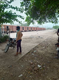 Rear view of men on road in city against sky