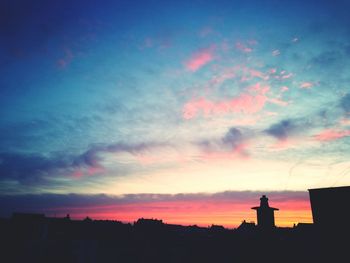 Silhouette city against sky during sunset