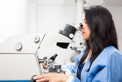 Young female scientist using an ultramicrotome to make sections for the electron microscope.