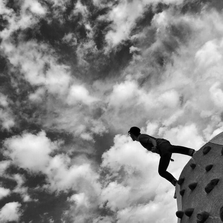 sky, low angle view, cloud - sky, cloudy, built structure, architecture, cloud, building exterior, day, leisure activity, statue, outdoors, sculpture, lifestyles, overcast, weather, men, history