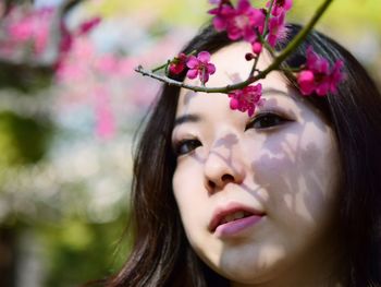 Close-up portrait of woman with pink flower