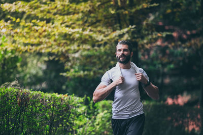 Determined young man running outside in the park. fit boy doing exercise outdoor. sporty male run