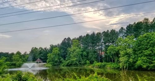 Scenic view of lake by trees against sky