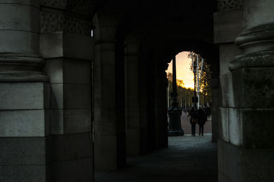 Rear view of woman walking in corridor of historic building