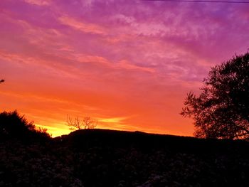 Scenic view of silhouette landscape against sky at sunset