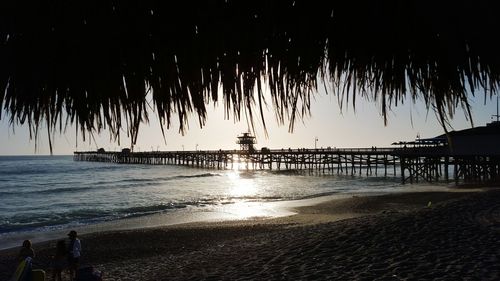 Pier on sea at sunset