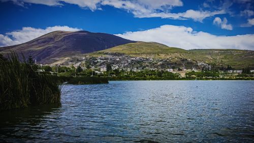 Scenic view of lake by mountains against sky