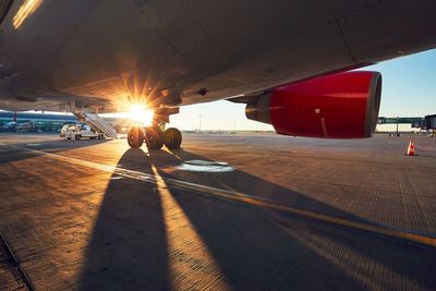 Airplane at airport runway during sunset