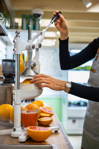 Cropped hands of woman making juice