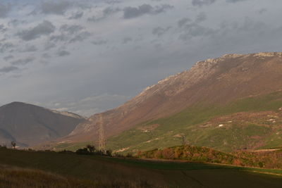 Road leading towards mountains against sky