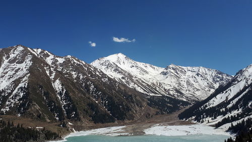 Scenic view of snowcapped mountains against clear sky