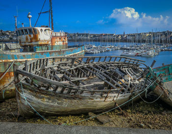 Fishing boats moored at harbor against clear sky