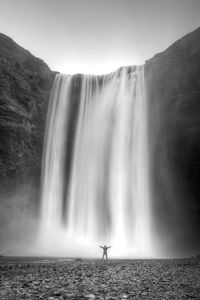 Rear view of a man looking at waterfall