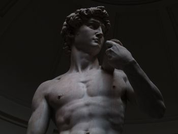 Young man looking away against black background