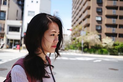 Portrait of woman standing on road in city