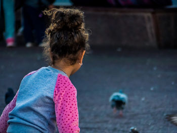 Rear view of girl standing in city