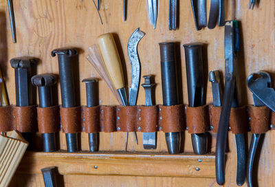 Close-up of tools hanging on wall in row