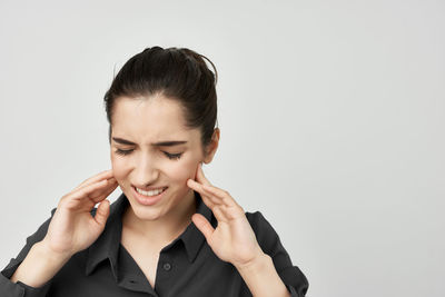 Portrait of young woman against white background