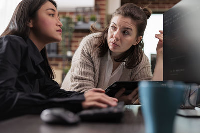 Portrait of young woman using laptop at table