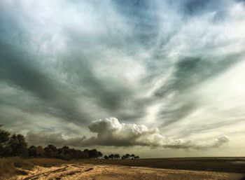 Scenic view of field against storm clouds