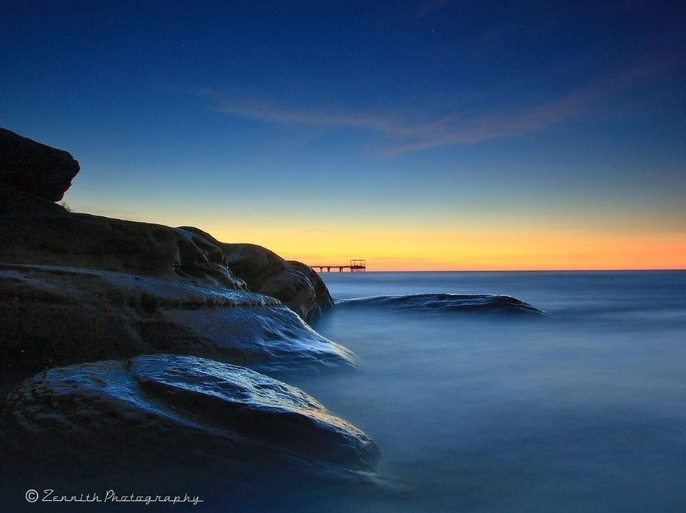 sea, water, horizon over water, sunset, scenics, beauty in nature, tranquil scene, sky, tranquility, beach, nature, shore, orange color, rock - object, wave, idyllic, rock formation, coastline, surf, blue