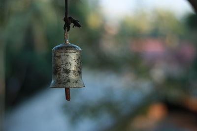 Close-up of old rusty metal hanging on wood at sunny day