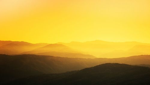 Scenic view of silhouette mountains against sky during sunset