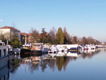 Boats moored in lake against clear sky