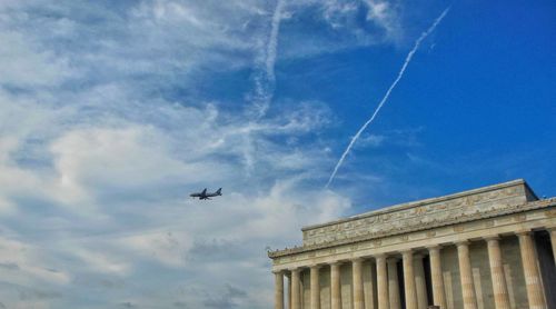 Low angle view of airplane flying against sky