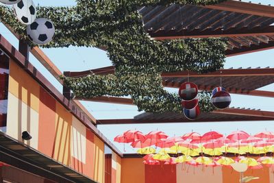 Low angle view of lanterns hanging by building against sky