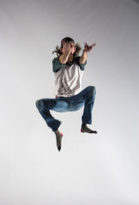 Full length of man jumping over white background