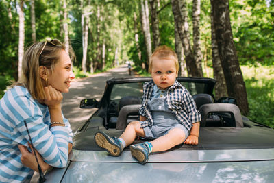 Mom and little son in a convertible car. summer family road trip to nature