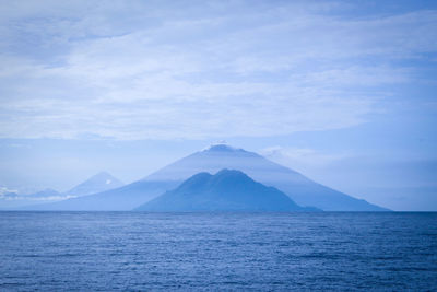 Scenic view of sea and mountains against sky