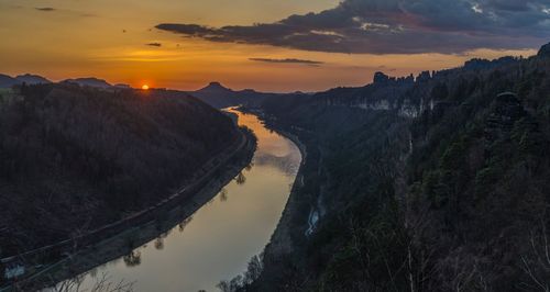 Panoramic view of river and mountains against sky during sunset