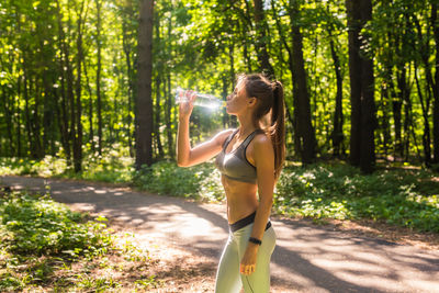 Young woman wearing sunglasses standing in forest