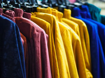 Multi colored clothes hanging on display at store