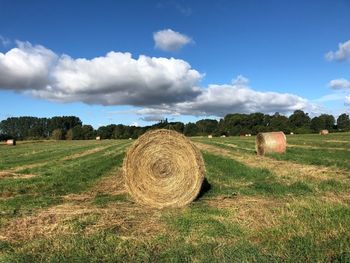 Hay bales on field against sky