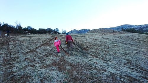 Rear view of women on landscape against sky