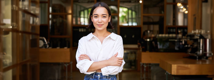 Portrait of young woman standing in library