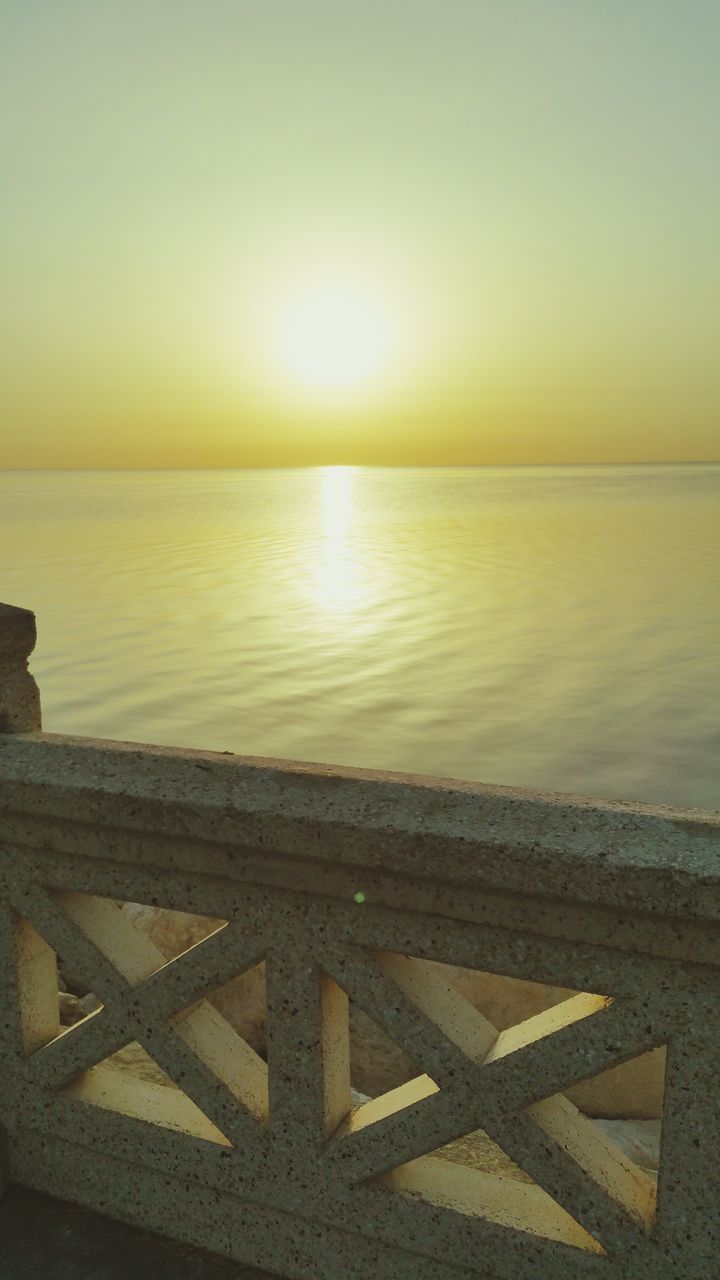 water, sea, scenics, tranquility, sunset, tranquil scene, nature, beauty in nature, railing, outdoors, horizon over water, sky, sun, no people, beach, sunlight, day